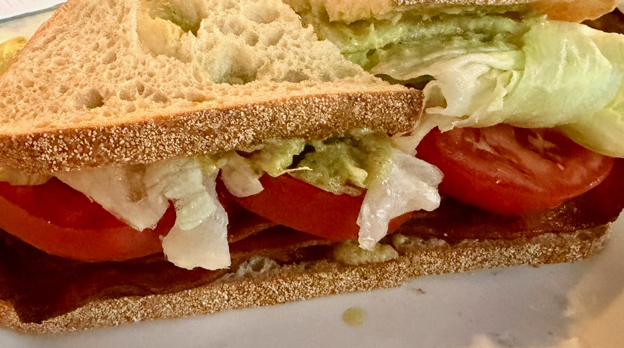 BLT test sandwich with thick tomato slices, iceberg lettuce and bacon on sourdough.