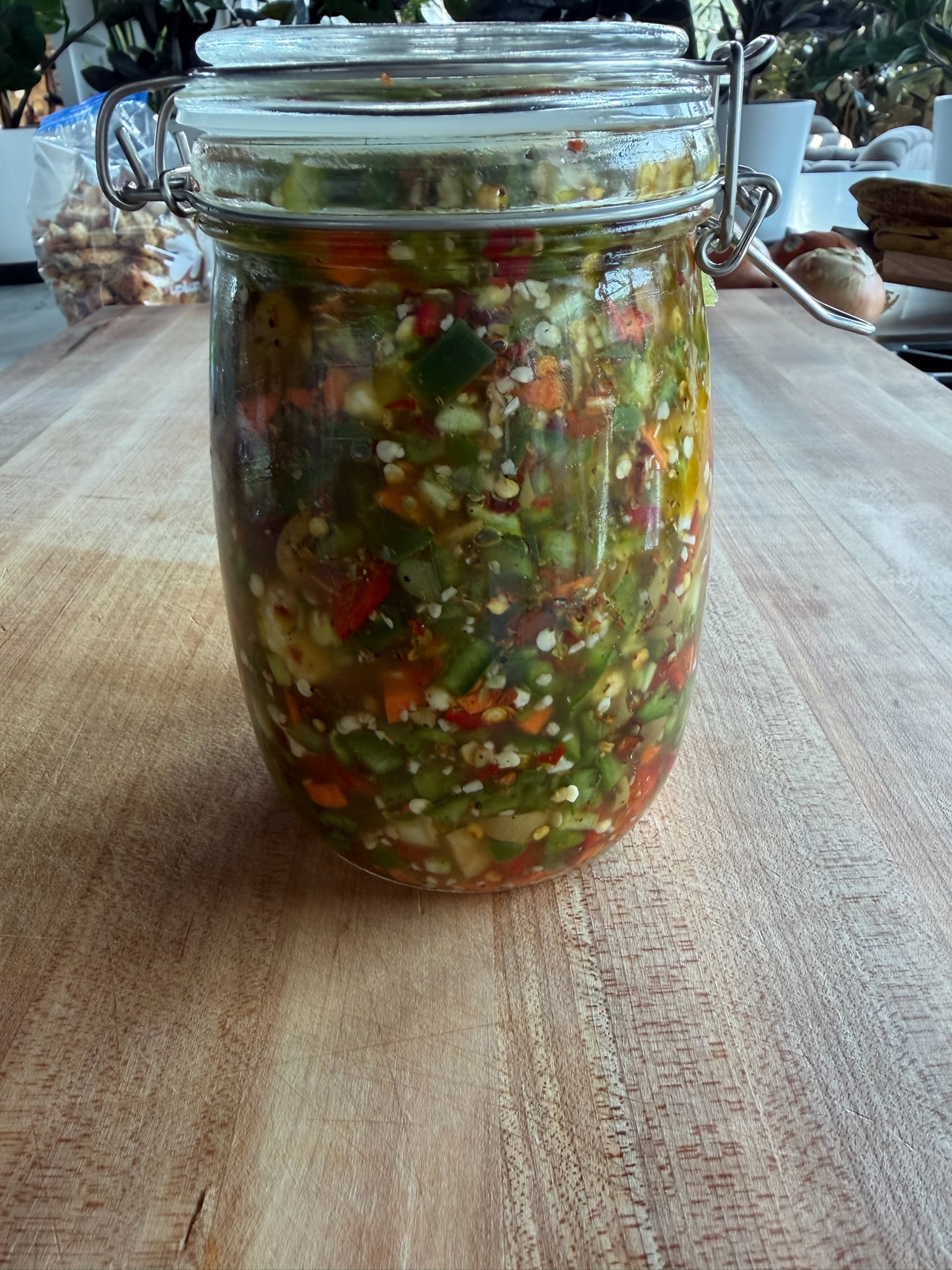 House-made giardiniera in a glass jar.