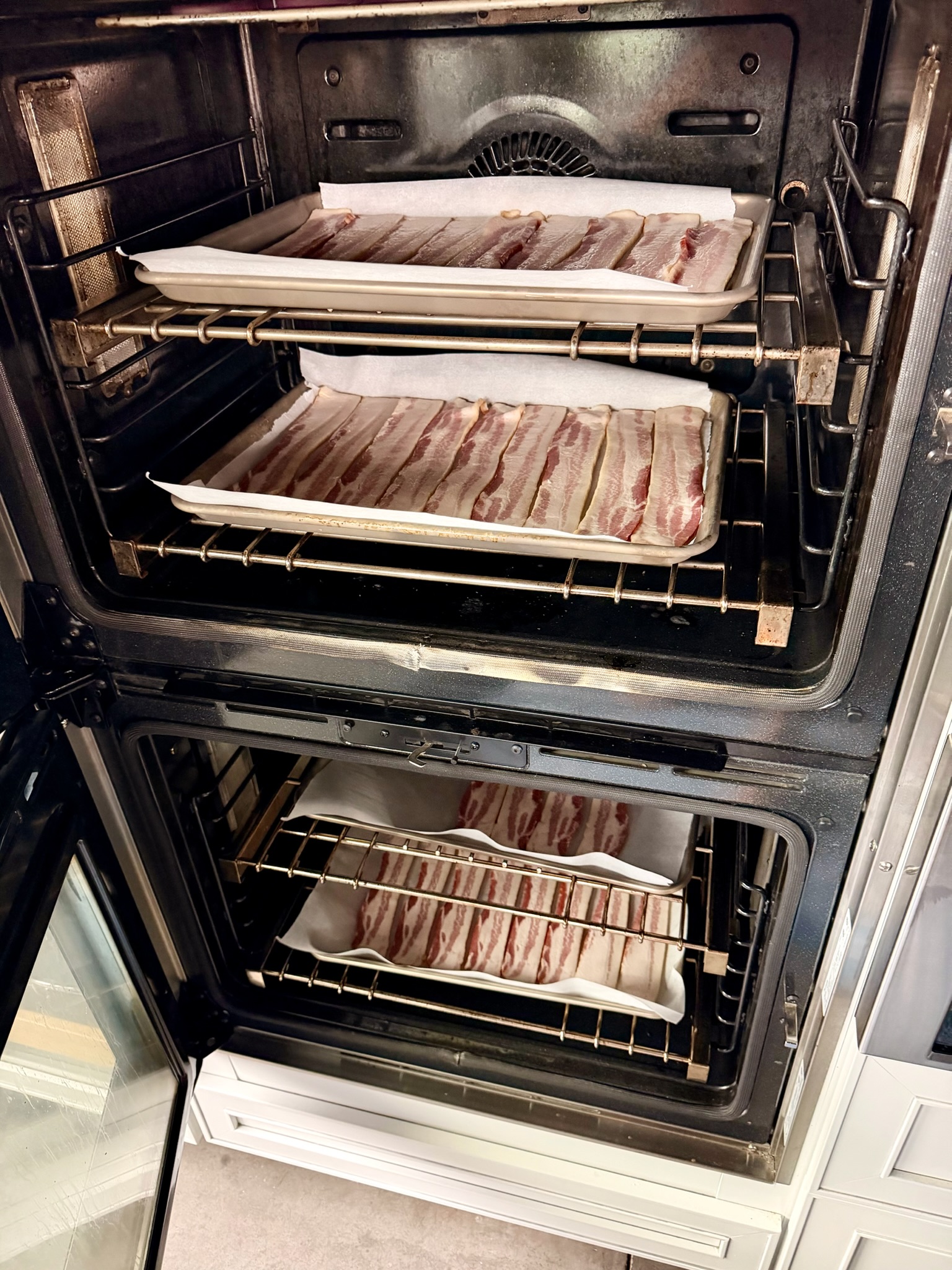 Bacon sheet pans in the oven.